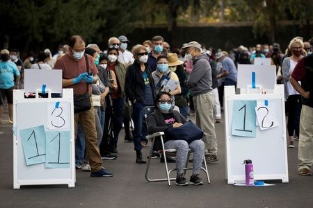 　１月１４日、米国の３７都市の市長はバイデン次期政権宛ての書簡で、新型コロナウイルスのワクチンを州政府を介さずに各都市に直接供給するよう求めた。ワクチン接種のため、会場となっているディズニーランドの駐車場に集まった人々、カリフォルニア州アナハイムで撮影（２０２１年　ロイター／Mario Anzuoni）