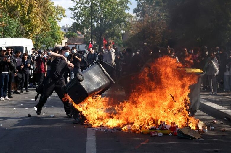 2026年10月1日、フランスのパリ近郊サンドニで、火の中にゴミ箱を投げ込む人。REUTERS/Abdul Saboor