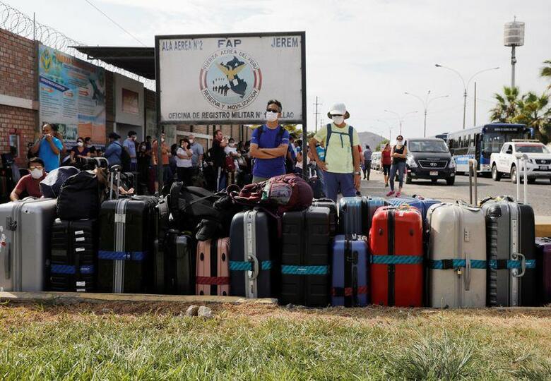 菅義偉官房長官は24日午後の会見で、ペルーに留め置かれた邦人について、出国に向け同国政府に働き掛けていると述べた。写真は非常事態宣言が出される前、ペルーの空軍基地で帰国便を待つアルゼンチン人。3月22日、リマで撮影（2020年　ロイター/Sebastian Castaneda）