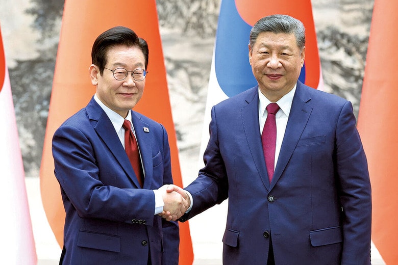 握手を交わす韓国の李大統領（左）と中国の習国家主席（1月5日、北京で）　CHINA DAILYｰREUTERS