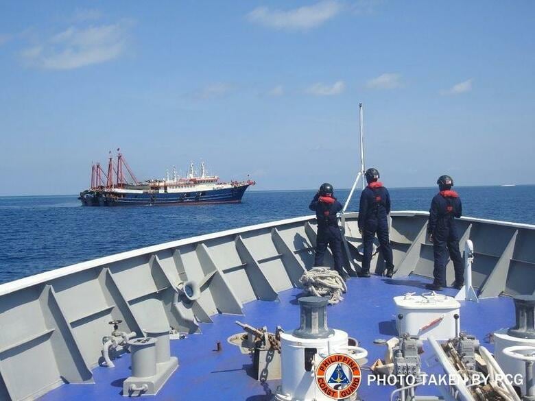 フィリピン外務省は南シナ海の自国が保有する島付近で中国が「違法なプレゼンス・活動」を継続していることに抗議したと表明した。写真は中国の武装船とみられる船を調べるフィリピンの沿岸警備隊。4月27日、南シナ海で撮影（2021年　フィリピン沿岸警備隊提供）