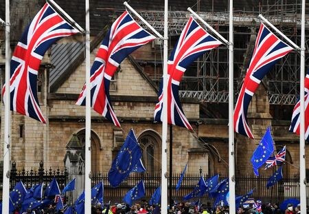 １２月２４日、英国と欧州連合（ＥＵ）は、自由貿易協定（ＦＴＡ）を含む今後の関係を巡る交渉で合意したと発表、英国のＥＵ離脱（ブレグジット）は「移行期間」終了の１週間前という土壇場で話し合いが決着した。写真は１月、英議会前に掲げられた英国旗と、ＥＵの旗（２０２０年　ロイター/Toby Melville）