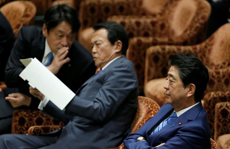 ４月２３日、毎日新聞朝刊は、安倍晋三内閣の支持率が前回比３ポイント低下の３０％となり、不支持率４９％を下回ったと伝えた。写真は１１日、衆議院予算委員会での安倍首相（右）、麻生財務大臣（中央）、小野寺防衛大臣（左）（２０１８年　ロイター／Toru Hanai）