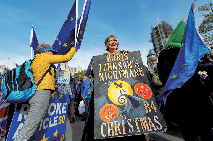 議会前でジョンソン批判のポスターを掲げる離脱反対派（10月30日）　YARA NARDI-REUTERS