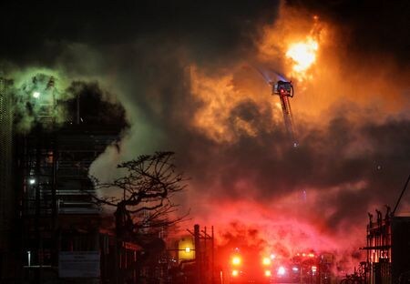 　ロサンゼルス近郊にあるシェブロンのエルセグンド製油所で２日夜、大規模な火災が発生、大きな炎と煙に包まれた。写真は消火活動にあたる消防隊（２０２５年　ロイター/Daniel Cole）