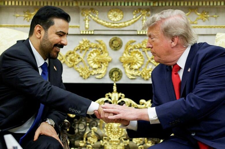 トランプ米大統領と握手を交わすイラクのザイディ首相。ホワイトハウスで１４日撮影。REUTERS/Evan Vucci