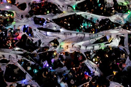 　１２月１２日、美容整形から旅行代理店、ホテルチェーンまで、韓国では外国人観光客を重要な収入源とする接客サービス業界全体で、足元の政治危機が長期化した場合に生じる悪影響に警戒感が広がっている。写真は同日、ソウルで尹錫悦大統領の弾劾を求めて抗議活動する人々（２０２４年　ロイター/Kim Soo-hyeon）