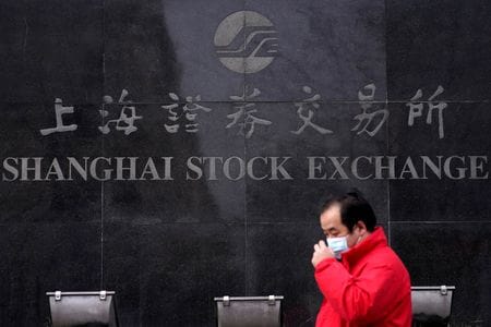 中国の株式市場ではテクノロジー（Ｔ）、メディア（Ｍ）、通信（Ｔ）のいわゆる「ＴＭＴ株」がＡＩ（人工知能）ブームを追い風に大幅に値上がりし、過熱を懸念する声が出ている。写真は2020年2月、上海証券取引所ビルのそばを歩く男性で、中国・上海の浦東金融街で撮影（２０２３年　ロイター／Aly Song）