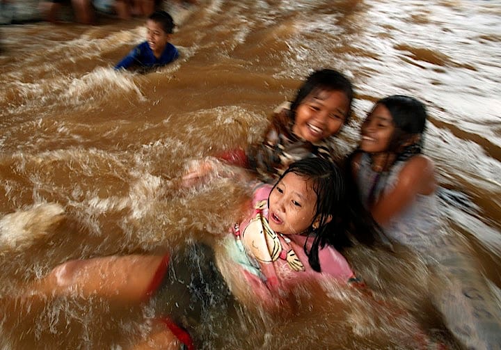 大雨で冠水した道路で遊ぶジャカルタの子どもたち。こういった経験が水没に動じない国民性を育てる？　Beawiharta Beawiharta - REUTERS
