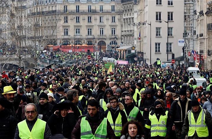 フランス各地で、マクロン政権に反発するデモが再び起き、パリでは一部の参加者がフォークリフトを使って政府庁舎に侵入したほか、観光名所シャンゼリゼ通り周辺で車に放火するなど暴徒化し、警官隊と衝突した。黄色いベストを着てデモに集まった人たち。パリで撮影（２０１9年　ロイター／Gonzalo Fuentes）
