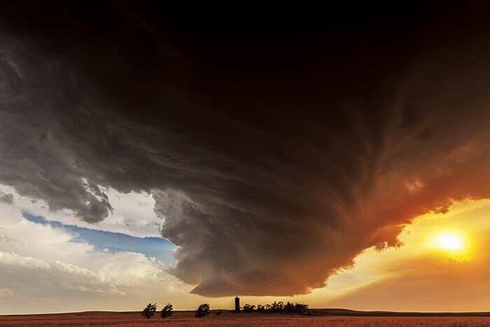 カミール・シーマン(Camille Seaman)<br>
<シリーズタイトル> 『ザ・ビッグ・クラウド』<br>
(The Big Cloud)<br>
<作品タイトル> 農場に現れた美しい怪物(2012年6月22日、ネブラスカ州ロッジポール、中部標準時19時15分)<br>
▶直径80キロ、高さ20キロに達するスーパーセル(巨大積乱雲)の迫力は、万物の二面性を物語る。破壊なくして創造はなく、強大な積乱雲は恐ろしくも美しい<br>
Credit: Courtesy Camille Seaman