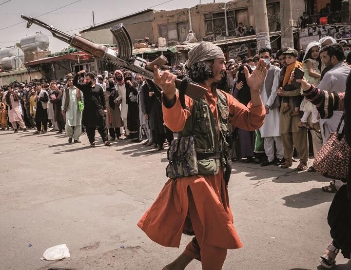 カブールの国際空港に向かう女性を殴ろうとするタリバン兵（8月18日）　JIM HUYLEBROEKｰTHE NEW YORK TIMESｰREDUX/AFLO