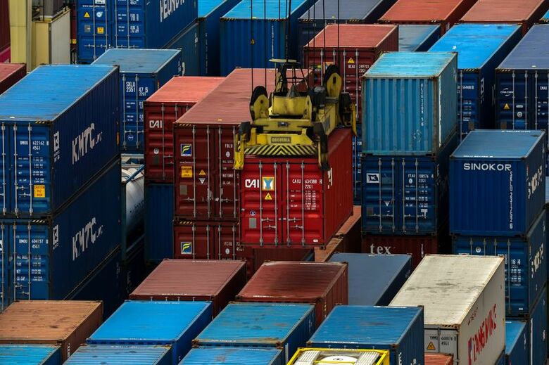 2025年7月8日、バンコク、停泊中の貨物船にコンテナが積み込まれる様子 REUTERS/Athit Perawongmetha