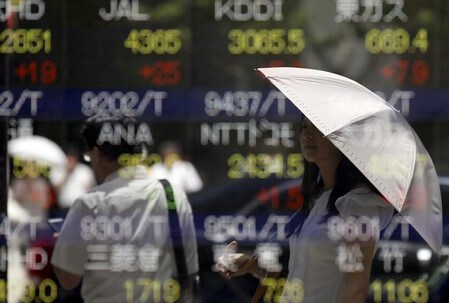 　７月１１日、寄り付きの東京株式市場で、日経平均株価は前日比１９４円７５銭安の２万２００２円１４銭となり、大幅反落で始まった。写真は都内の株価ボードに映る通行人。２０１５年７月撮影（２０１８年　ロイター／Toru Hanai）