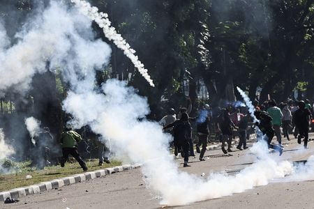 　８月２９日、インドネシアで２８日、学生らが議会前でデモを行っていた際に、オートバイのドライバーの男性が警察車両にはねられ、死亡した。写真は、機動隊との衝突で催涙ガスから逃げるデモ参加者。ジャカルタで２９日撮影（２０２５年　ロイター/Willy Kurniawan）