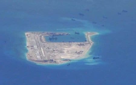 　６月２５日、中国が南シナ海の南沙諸島で進める岩礁の埋め立て工事。海洋環境の専門家の間では、東南アジアで最も重要なサンゴ礁生態系の１つに深刻なダメージを与えていると危惧する声が高まっている。写真は永暑礁で、米海軍の提供映像から（２０１５年　ロイター）