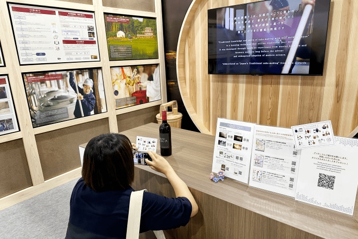 オリジナルポストカードの写真を撮る来場者