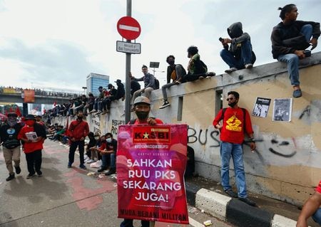 インドネシア各地で６日、議会で可決された雇用関連法に反発する労働者の抗議集会が行われた。政府は投資誘致のために新法が不可欠としているが、労働組合などからは過度にビジネス寄りとの批判が上がっている。写真は、インドネシア議会の前で「オムニバス法案」の取り消しに抗議する労働者の組織に加盟しているメンバー。２０２０年７月１６日にジャカルタで撮影。（２０２０年　ロイター／Ajeng Dinar Ulfiana）