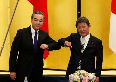 茂木敏充外相は２４日、中国の王毅国務委員兼外相と都内で会談した。両国は新型コロナウイルス感染症への対応で連携することで一致し、日中間のビジネス往来を１１月中に再開する方向で一致した。写真は両外相。都内で２４日撮影。（2020年 ロイター/Issei Kato/Pool ）
