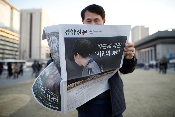 朴槿恵大統領の罷免を伝える新聞を読むソウル市民（3月10日）　Kim Hong-Ji-REUTERS