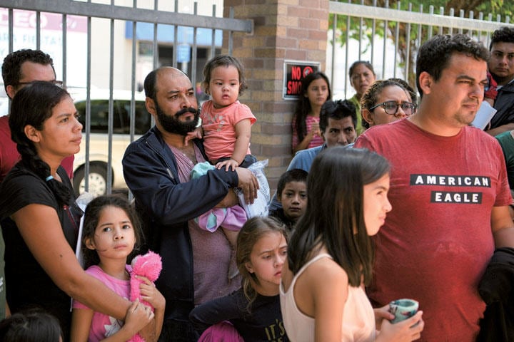 メキシコ国境に近いテキサス州マッカレンの不法移民収容センターを出所し、バスを待つ人々　LOREN ELIOTT-REUTERS