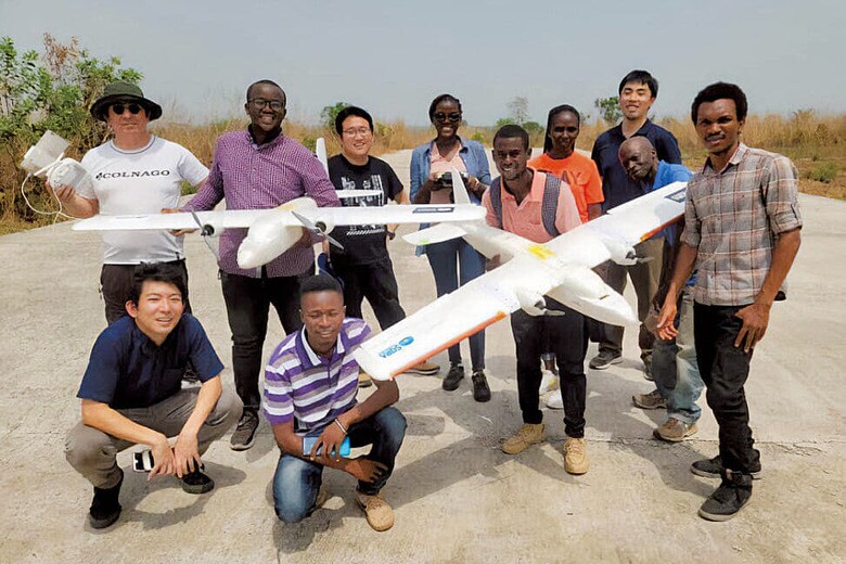 アフリカ西部のシエラレオネで、ドローンを使った実証実験を行う金子（前列左）　COURTESY OF SORA TECHNOLOGY