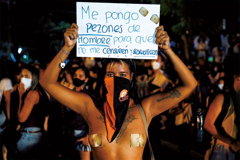 男性の乳首の写真を張った姿で抗議するパラグアイの女性　AP/AFLO
