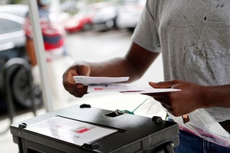 米大統領選で激戦が予想されるフロリダ州で１９日、期日前投票が始まった。州内各地に設置された投票所前には数百人の有権者が列を作った。写真は同州イーストタンパで郵便投票をする市民、８月撮影（２０２０年　ロイター/OCTAVIO JONES）