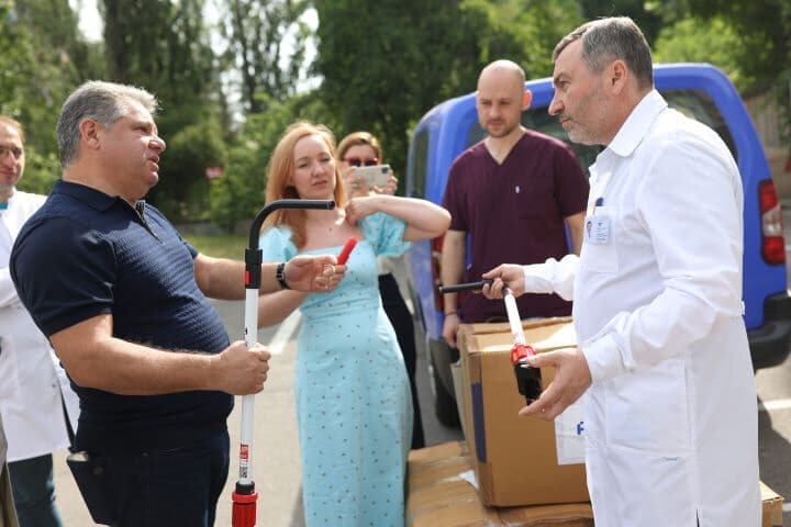 6月17日、車イスの補助具「JINRIKI QUICK」10セットを手渡された国立がん研究所のシプコ所長（右、FFU提供）