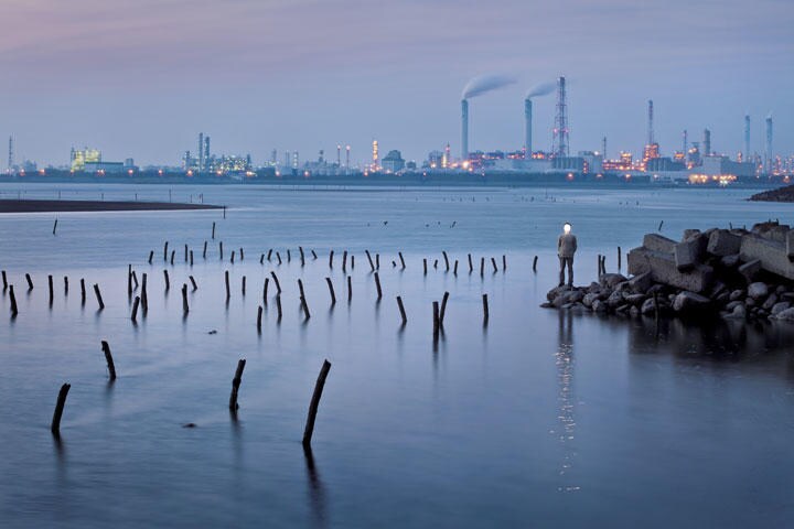 【台西　2009】夜明けの空に美しく輝くのは台湾最大の石油化学工業団地。手前にはカキ養殖場が広がる。工業と漁業、どちらも人々の生活を支えるのに欠かせないものだが、ここでは2つがあまりに近接しており、経済活動と環境のバランスを考えずにいられない