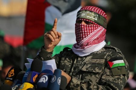 　パレスチナ自治区ガザを実効支配するイスラム組織ハマスは１１月１３日、人質解放などで仲介しているカタールに対し、５日間の停戦と引き換えに、ガザで拘束している人質の中から最大７０人の女性と子供を解放する用意があると伝えたと明らかにした。写真はハマスの軍事部門「カッサム旅団」のアブ・オバイダ報道官。２０１９年１１月、ガザで撮影（２０２３年　ロイター/Ibraheem Abu Mustafa）