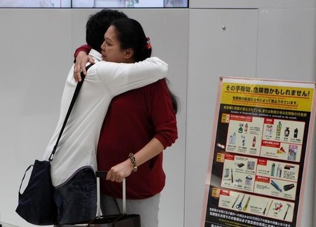 　１１月２２日──９月半ば、朝の成田国際空港。１６歳の少年ウティナン・ウォン（左）はタイに帰国する母を固く抱き締めた後、出発ゲートに消えていく後姿をじっと見送った。９月撮影（２０１６年　ロイター/Thomas Wilson）