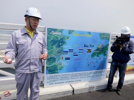 　５月１９日、香港と中国本土の珠江デルタを結ぶ、長さ約３０キロの橋が完成に近づくなか、中国の当局者らは、香港との緊張が高まっているこの時期に、この橋が経済統合以上のものをもたらすことを期待している。写真左は建設プロジェクト責任者の１人である中国当局のWei Dongqing氏。珠海市で１７日撮影（２０１７年　ロイター/James Pomfret）
