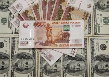 　１月２１日、ロシア通貨ルーブルの下げが止まらない。２１日には初めて１ドル＝８４ルーブル台をつけて過去最安値を更新。ナビウリナ中銀総裁は、ダボス会議出席を取りやめた。写真はルーブル紙幣とドル紙幣、サラエボで２０１５年３月撮影（２０１６年　ロイター/Dado Ruvic）