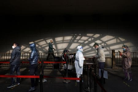　中国は、新型コロナウイルスを最も危険度の高い感染症と同等の対応を必要としている現在の分類について、ウイルスの危険性低下に応じて見直す機運が高まりつつある。中国紙、第一財経が報じた。写真は検査に並ぶ人々。北京で４日撮影（２０２２年　ロイター／Thomas Peter）