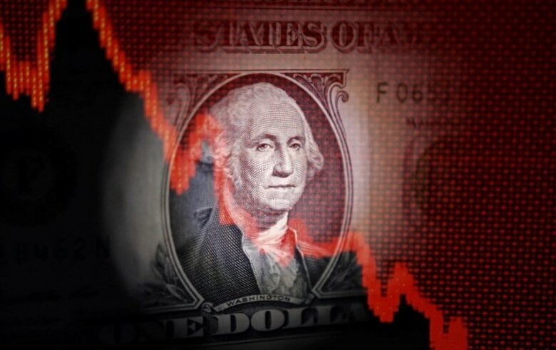 写真は米ドル紙幣と、減少傾向のグラフのイメージ。2025年4月撮影。REUTERS/Dado Ruvic
