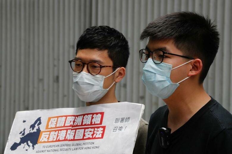 香港民主派による2014年の大規模デモ「雨傘運動」を主導した羅冠聡（ネイサン・ロー）氏（写真左）は、フェイスブックへの投稿で香港を離れたことを明らかにした。写真右は黄之鋒（ジョシュア・ウォン）氏。香港で６月撮影（2020年　ロイター／Tyrone Siu）